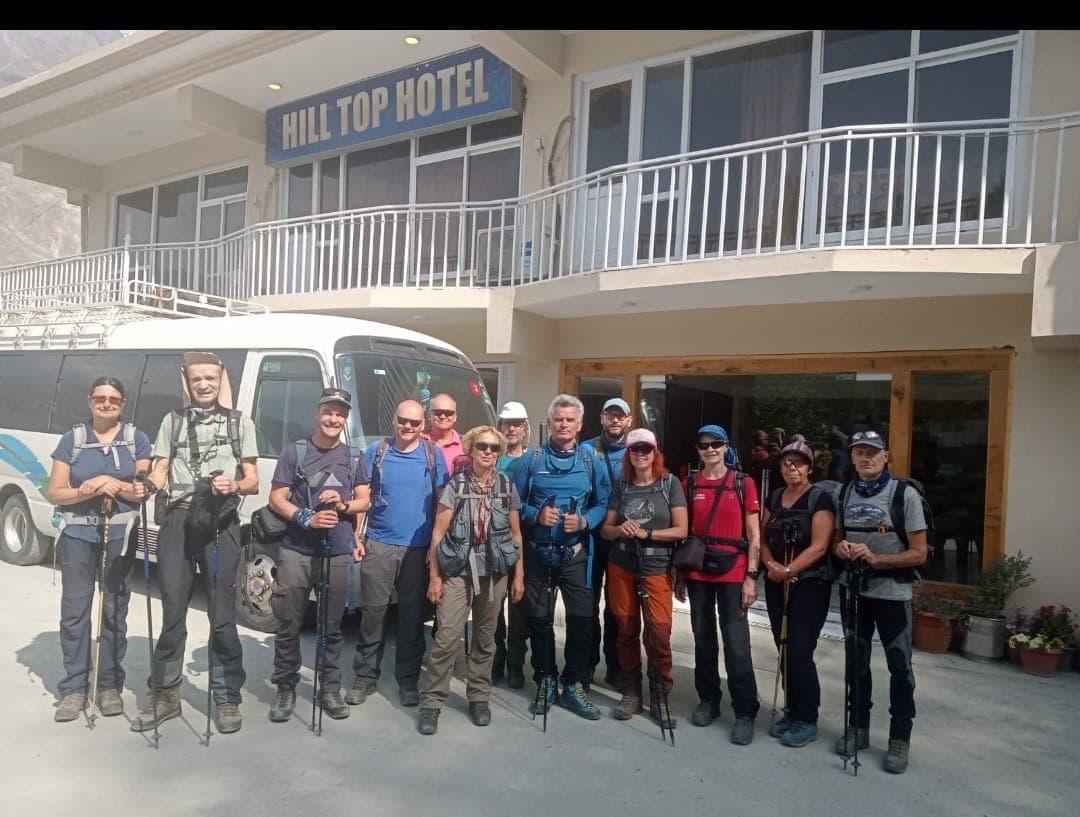 International travelers gathered outside Hilltop Hotel Hunza before a valley excursion